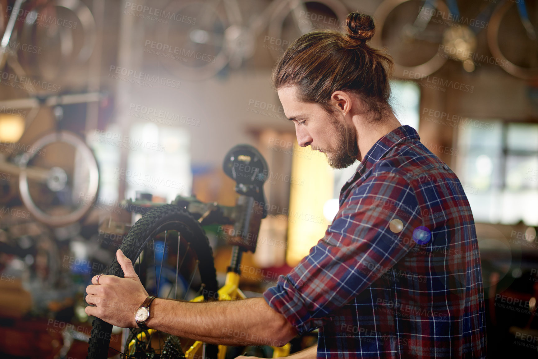 Buy stock photo Small business, building or man with bike in workshop or store for fixing, maintenance or upgrade. Wheel alignment, warehouse or mechanic in garage for bicycle parts, mechanical engineering or repair
