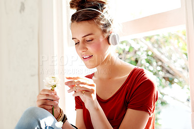 Buy stock photo Home, headphones and teenage girl with flower, relax and weekend break with audio, radio and sound. Apartment, podcast and happy person with plant, white rose and listening to music, nature or spring