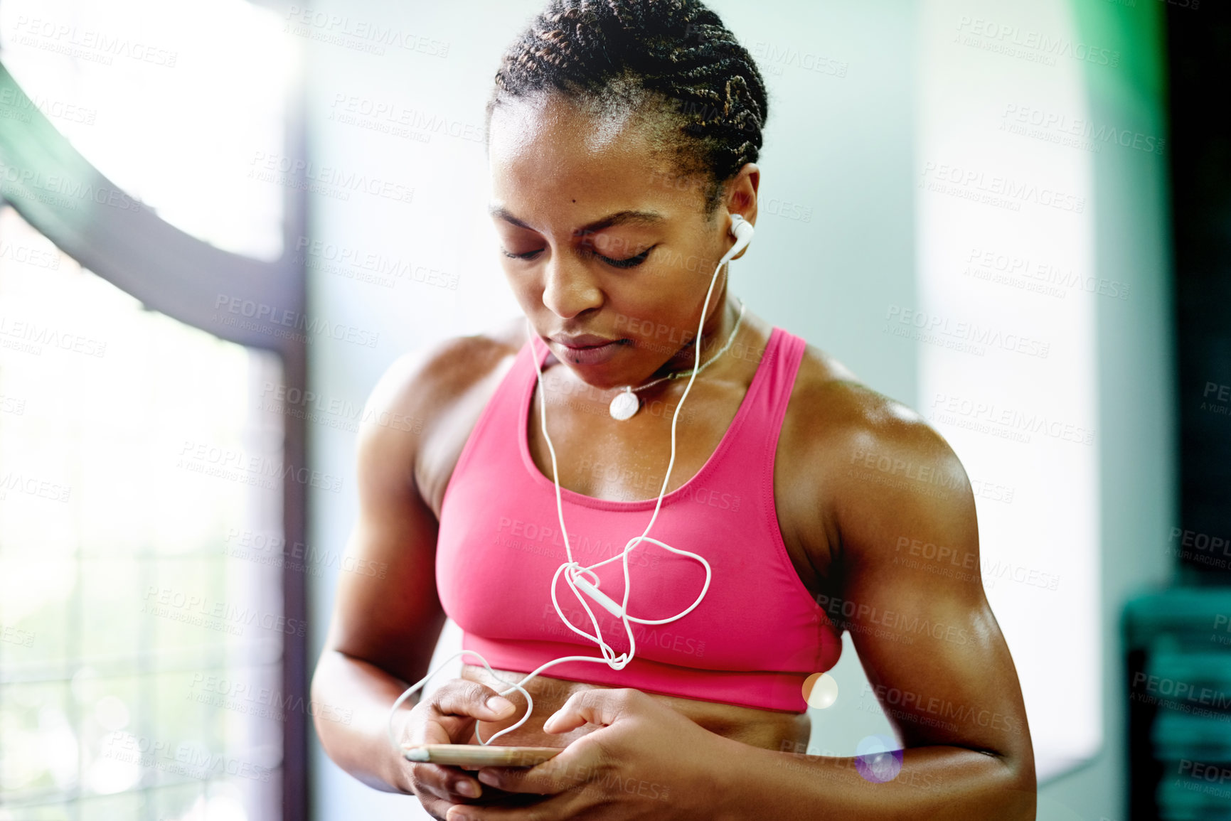 Buy stock photo Black woman, earphones and smartphone for fitness at gym, sound and music subscription for exercise. African girl, phone and listen to audio on mobile app for album, song or radio at training center
