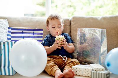 Buy stock photo Boy, toddler and candle on cupcake for birthday party, celebration and wish on special occasion. Child, blowing and cake with presents for event, family tradition and memories for milestone at house