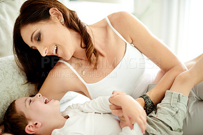 Buy stock photo Happy mom, playing and lying with child in bed for love, comfort or playful weekend in home. Mother, kid or son with smile or parenting for youth development, childhood growth or bonding in house