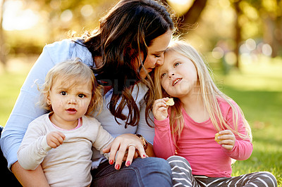 Buy stock photo Relax, mother and children in park with support for bonding, connection and family time on summer picnic. Trust, caring woman and daughter with snacks on lawn, love and rest together on weekend.