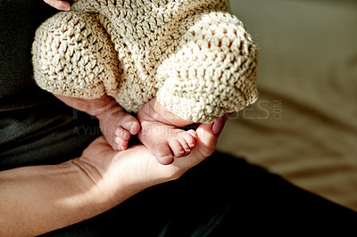 Buy stock photo Parent, hands and newborn baby with feet in cotton clothing for infant fashion or childhood in home. Closeup, child or kid with toes or touch for youth development, growth or knitted wear in house