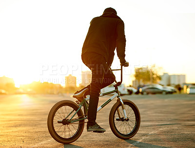 Buy stock photo Back, man and riding bicycle in city for travel, endurance training and cardio exercise. Male person, sunrise and bike with fitness skills, sports workout and sustainable transport for stunt practice