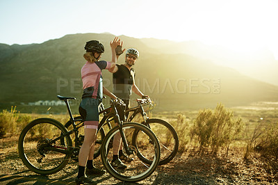Buy stock photo High five, health and bicycle with couple in nature for triathlon training, sports athlete or team. Cardio workout, cycling partner and resting stop with man and woman outdoor for exercise and space
