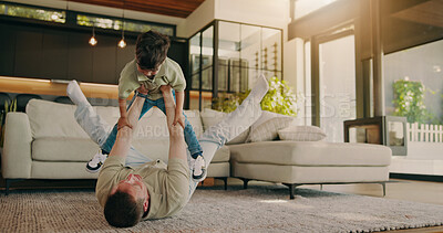 Buy stock photo Fun, father and child on floor with lifting, happy moment and bonding together with home playtime. Smile, dad and kid with family game, parent connection and quality time with playful relationship.