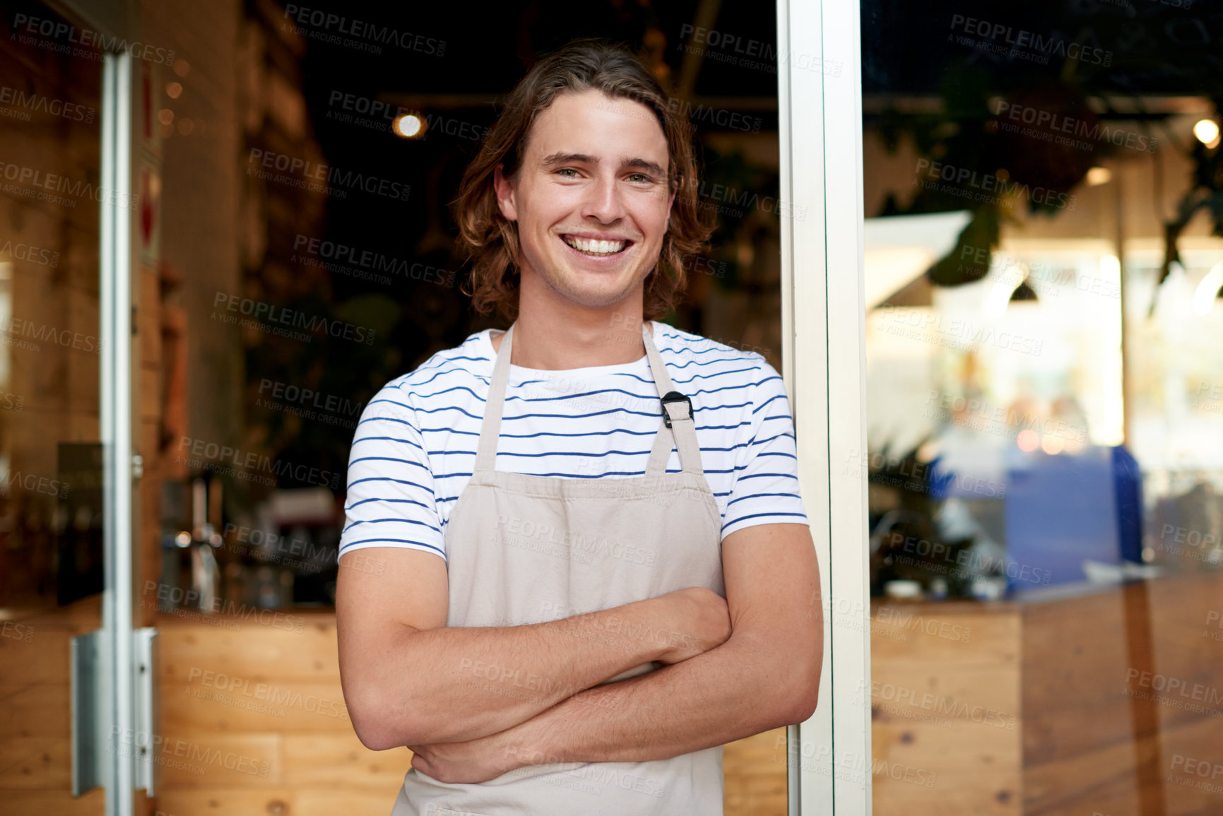 Buy stock photo Portrait, waiter and man with arms crossed, small business and pride for hospitality, apron or cafe. Happy, employee and person with smile at entrance, welcome or confident for coffee shop in USA