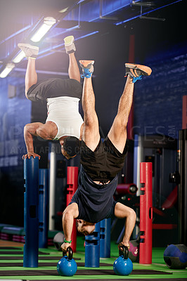 Buy stock photo Gym, handstand or people with balance on kettlebell in fitness for practice, training or workout. Athletes, flexible or gymnasts in club with weights for athletics, acrobatics or upside down exercise