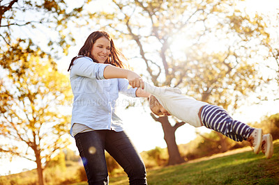 Buy stock photo Mom, spin child and happy at park with game, bonding and low angle with love, care and summer in nature. People, mother and daughter with smile, swing or play for fun with family in New Zealand