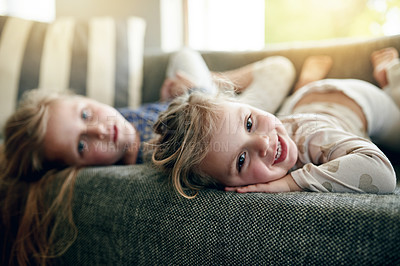 Buy stock photo Portrait, siblings and bonding on sofa, lounge and girls with smile on break, children and together. Happy, sisters and relax on couch, home and kids in living room, chill or family in apartment