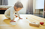 Boy kid, blocks and playing on floor in home, childhood growth and fun development. Baby, educational wooden toys and games for montessori learning, creative puzzle and motor skills in nursery room