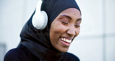 Buy stock photo Laugh, fitness and muslim woman with headphones, music streaming or listen to radio with happiness. Hijab, athlete and black person with song playlist, funny and smile on audio break in city outdoor