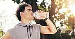 Fitness, man and drinking water at park for wellness, health lifestyle or workout pause for recovery. Runner, male person and break with hydration bottle outdoor, electrolytes or thirsty in summer