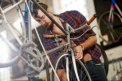 Buy stock photo Fixing, bicycle and man in workshop, service and inspection of damage in small business and serious. Repair, wheel and person with bike, entrepreneur or maintenance of vehicle, technician or shop