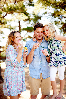 Buy stock photo Happy, parents or child blowing bubbles in nature, bonding together or playing for connection. Smile, family or daughter outdoor with summer activity for fun, support or childhood memory on weekend
