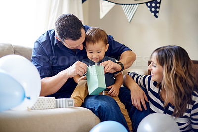 Buy stock photo Birthday, family and toddler with present, house and celebration for first party, mother and father. Happy, woman and man with gift for child, growth and development of son, break or parents in home