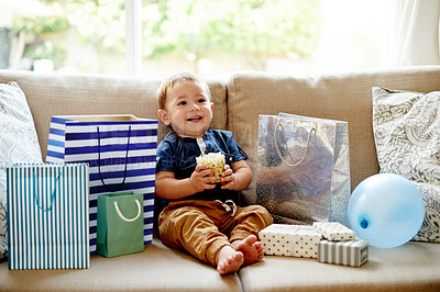 Buy stock photo Smile, toddler and eating cupcake at birthday party, celebration and dessert on special occasion. Boy, child and cake with presents for fun event, family tradition and sweet snack for moment at house