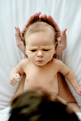 Buy stock photo Baby, above and hands of parent in nursery with bonding, frown or serious face with head support. Family house. people and early child development with connection, scowl or grumpy infant in home