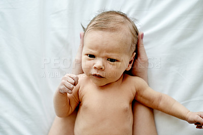 Buy stock photo Baby, above and hands of parent in portrait with bonding, frown or serious face with head support in family house. People, early child development and connection, scowl or grumpy infant in home