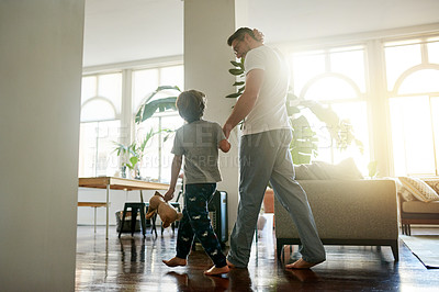 Buy stock photo Back, father and son walking in lounge with hand holding for morning bonding, conversation and waking up. Love, caring man or child in home for trust development, flare or support in communication