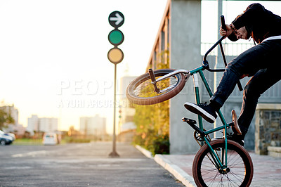 Buy stock photo Man, bike and jump stunt in city street with challenge, talent or action outdoor for extreme sports. Skill, trick or wheelie with person, athlete or rider for urban performance, bicycle and energy
