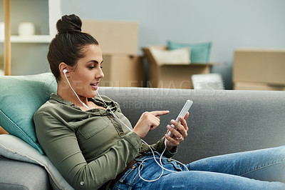 Buy stock photo Earphones, sofa and woman with music in home to relax with playlist, podcast and online streaming. Happy, phone and person in living room listening to song, track and audio subscription on weekend