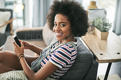 Buy stock photo Phone, portrait and text message with woman on sofa in living room of home for online post or update. App, communication and smile with happy African person in apartment for download or mobile chat