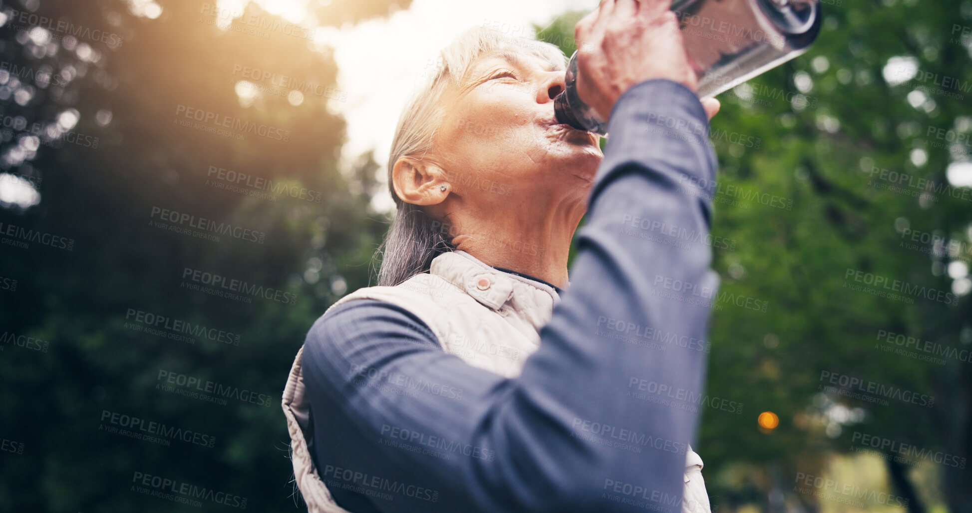 Buy stock photo Senior, woman and drinking water in nature for hydration, outdoor fitness or workout break in park. Active, elderly or female person with mineral liquid bottle for thirst, sustainability or recovery