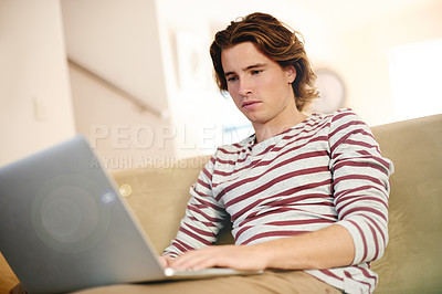 Buy stock photo Laptop, typing and man on sofa for research, reading and university scholarship email in home. Tech, application and male student in living room for college admission test, exam or study assignment