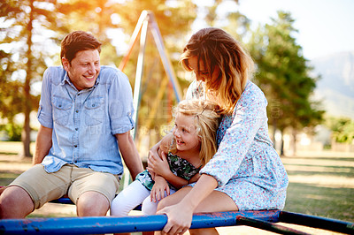 Buy stock photo Playground, parents and girl on merry go round for family weekend fun, happy bonding or love. Smile, caring man and woman with child on playing equipment together, park visit or support in summer.