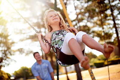 Buy stock photo Happy child, playground and man at park with swing in air, bonding and sunlight for fun childhood memories. Smile, nature and daughter outdoor with father, laugh together and playing for connection.