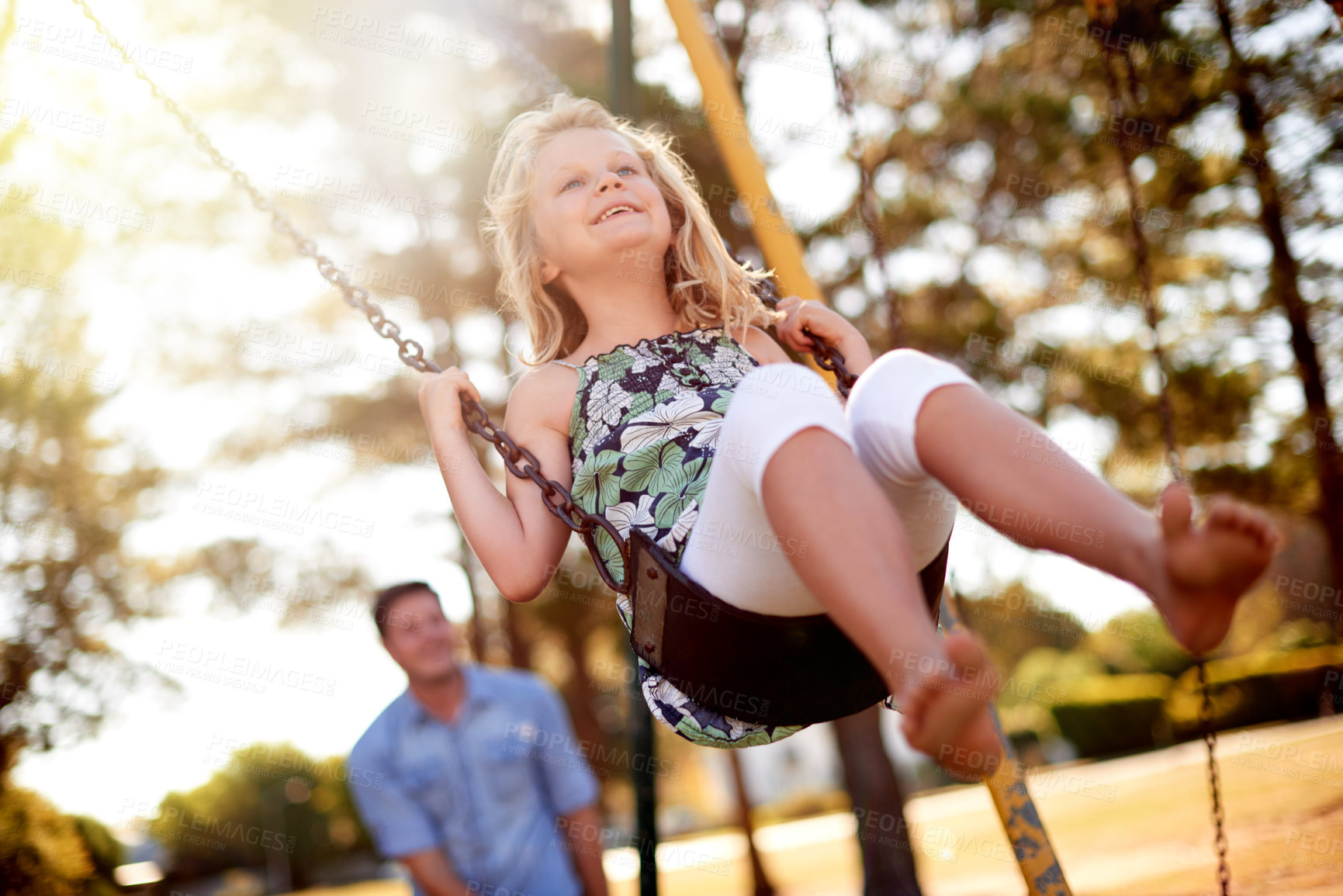 Buy stock photo Happy child, playground and man at park with swing in air, bonding and sunlight for fun childhood memories. Smile, nature and daughter outdoor with father, laugh together and playing for connection.