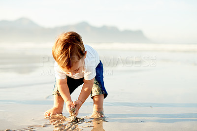 Buy stock photo Boy, toddler and playing in sand at beach with childhood, holiday and space outdoor for travel. Adventure, nature and mockup for summer fun with male kid by ocean with games on vacation in Spain