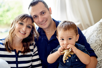 Buy stock photo Toy, happy family and parents in home with child for love, care and bonding with portrait. Mother, father and kid in living room with toddler playing with dinosaur, relax or smile together in Germany