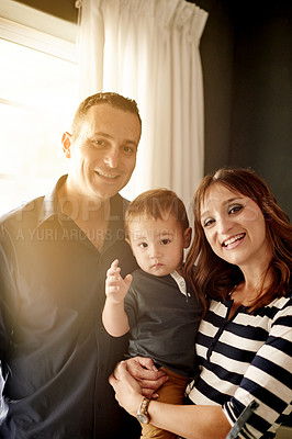 Buy stock photo Portrait, happy family and parents in home with child for love, care and bonding. Mother, father and kid in living room with toddler for support, connection and smile together with flare in Germany