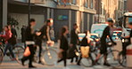 People blurred walking biking through the city