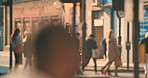 A blurred group of people waiting to cross the street together