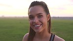 A cheerful woman laughing during a break from her workout routine. A happy young woman smiling before her workout on the promenade. A young woman on the promenade about to exercise at sunset