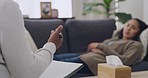 Young woman lying on a chair in session with a psychologist. Talking to her therapist about her problems and working through difficult emotions or memories. Therapy is helpful improving mental health