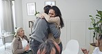 Closeup of a two people hugging and making peace during a group therapy rehab session. Group of employees dealing with issues during a team counselling session. Mental health in the workplace