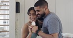 Young cheerful mixed race couple dancing and singing together at home. Joyful boyfriend and girlfriend having fun being playful in the kitchen. Husband and wife having fun and bonding