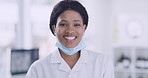 Happy African female doctor smiling in her office during covid. Portrait of black woman healthcare professional with a bright smile. Beautiful and joyful surgeon standing at the hospital 