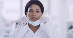 Portrait of black doctor covering her face with a mask while wearing gloves in a hospital with copyspace. Practicing  precautions during the corona virus pandemic. Health and safety in the workplace