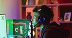 Young gamer playing online video games on a computer monitor with green screen copy space. Streamer using a headset with a microphone and a controller while multiplayer gaming in the metaverse