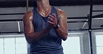 Fit man putting talcum powder on his hands and exercising on a gymnastics rings during his workout at the gym. Sportsman doing pull up exercise for stronger arm and back muscles in a fitness facility