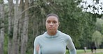 Active young woman running and jogging in a park outdoors from below. One focused and determined athlete doing cardio exercise while training for a marathon. Leading a fit and healthy lifestyle