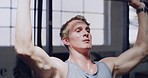Fitness man doing pull ups exercise at the gym. Muscular sportsman sweating during his upper body strength workout and challenging himself to reach his endurance goal for stronger muscles