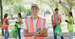 Male volunteer with a clipboard in the park. Group of people doing charity work by cleaning up litter in outdoors in their community. Diverse young people conducting neighbourhood cleanup program