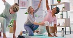 Senior yoga instructor teaching yoga pose to mature women in her exercise class. Active ladies practicing yoga with the help of an instructor in her studio. Living an active and healthy lifestyle