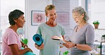 Diverse happy woman using a. digital tablet and talking after yoga class. Two pilates members speaking to an instructor in a health and wellness club before exercising in a cardio fitness  session